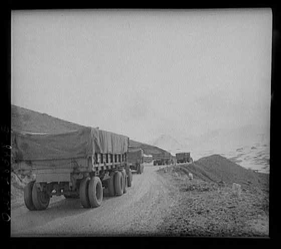 Somewhere in the Persian corridor. A United States Army truck convoy carrying supplies for Russia climbing a mountain road.