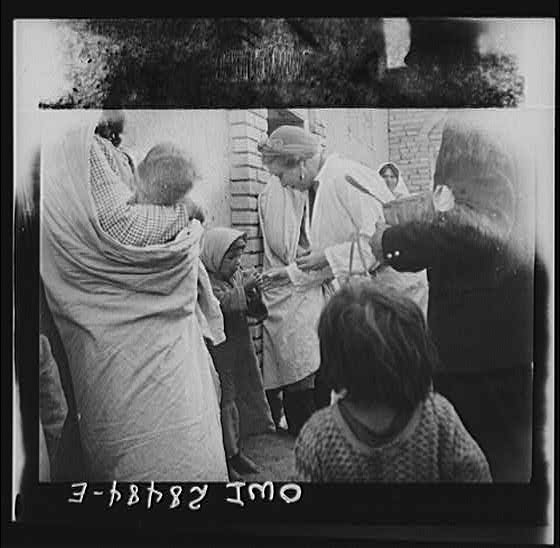 Teheran, Iran. Mrs. Louis Dreyfus, wife of the United States Minister to Iran, distributing food in the poorer section of the city.