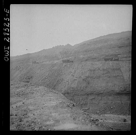 Somewhere in the Persian corridor. A United States Army truck convoy carrying supplies for Russia on a ledge of a rocky mountain.