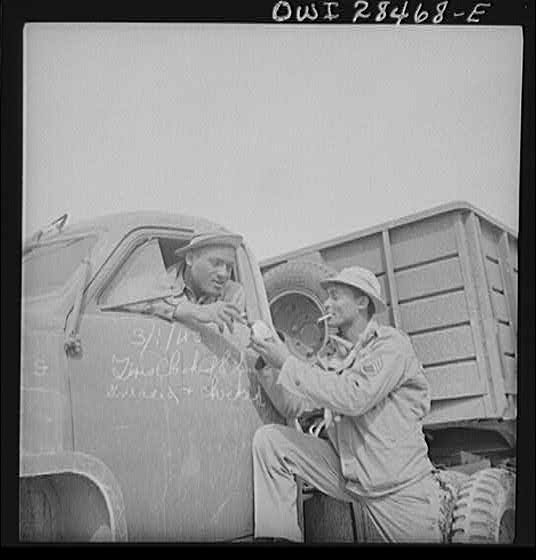 Somewhere in the Persian corridor. A United States Army truck convoy carrying supplies for Russia stopping to check trucks and for the drivers to have a smoke on the desert.